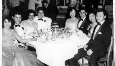 Students sitting at table dressed up at senior prom